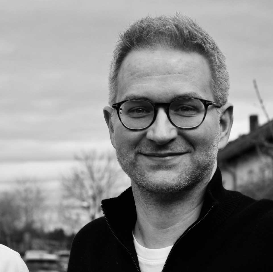 Portrait of Stefan Schultz, black and white photo, glasses, smiling